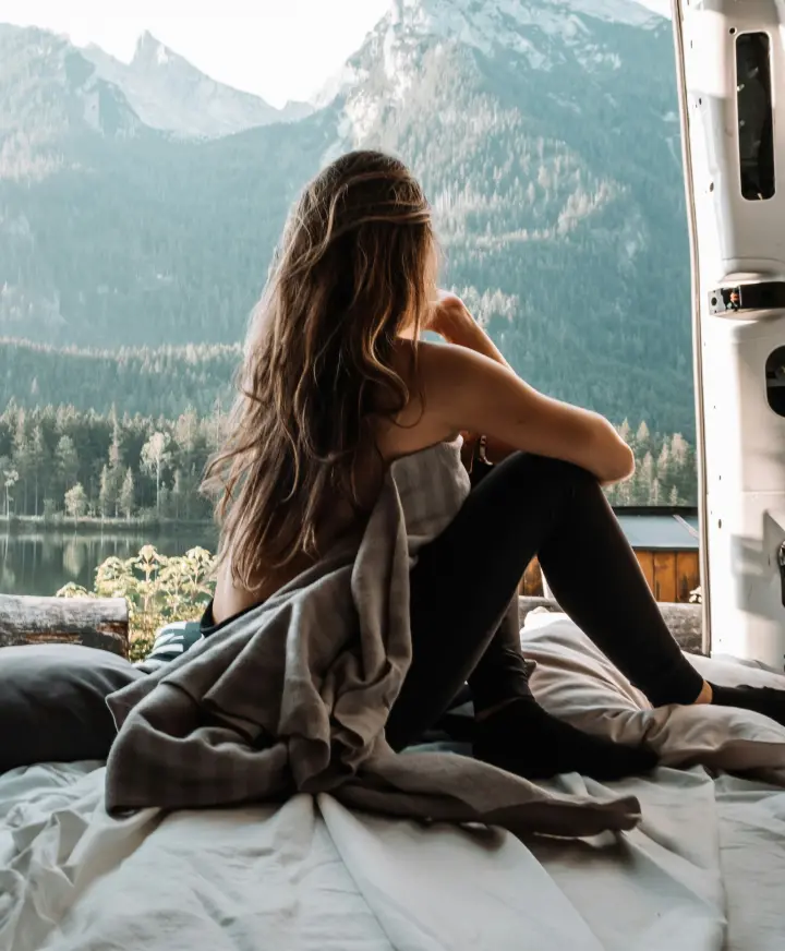 Woman in campervan looking out to lake